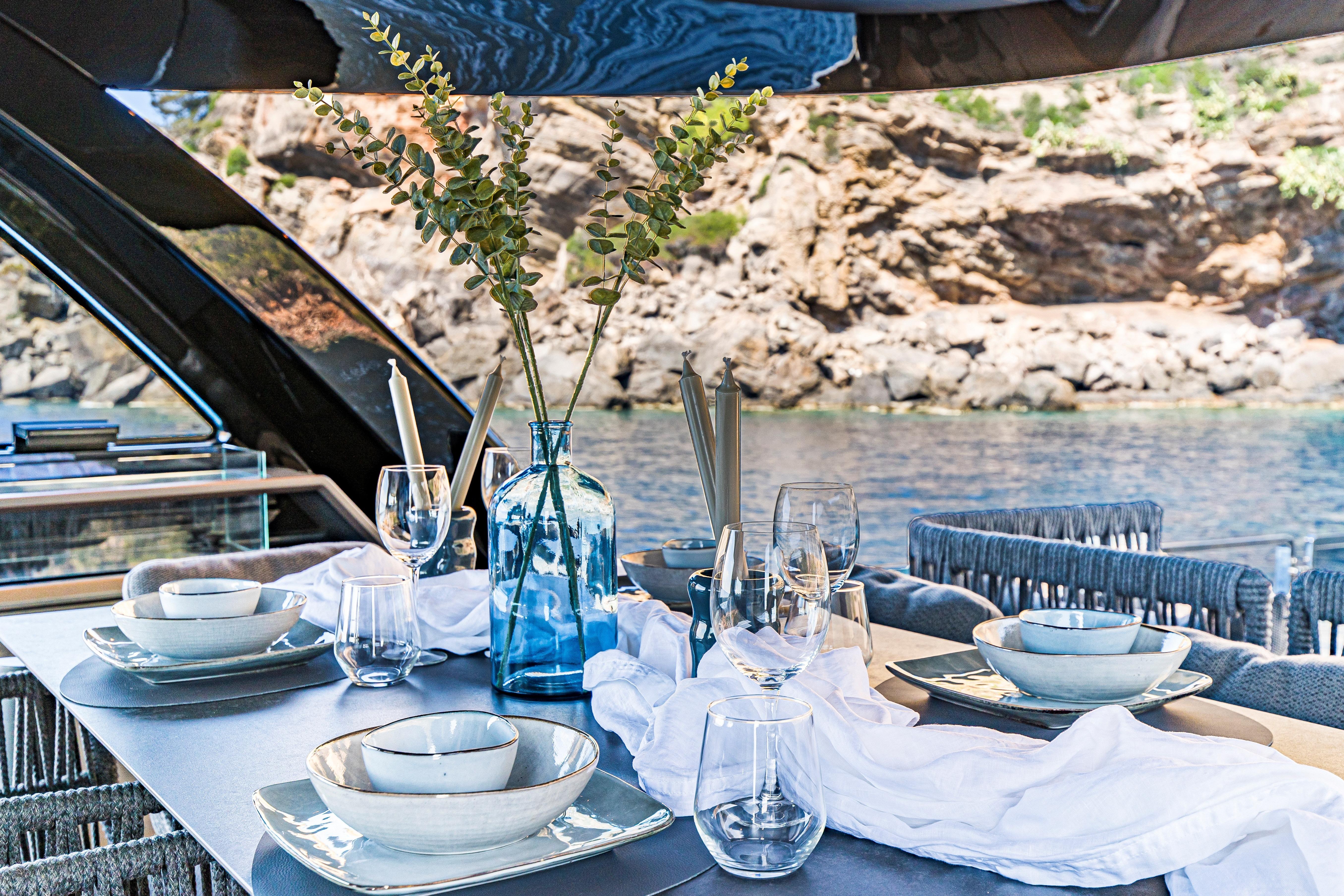 Elegant dining setup on 2024 Explorer EX62 yacht, featuring scenic ocean view.