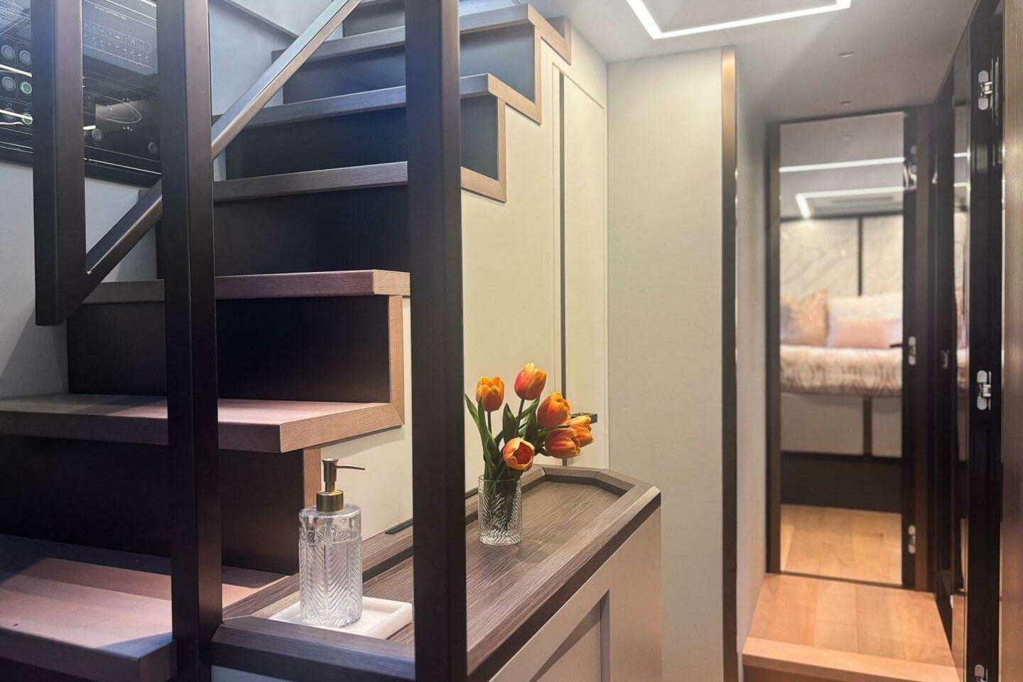 Luxurious interior of 2024 Explorer EX62 yacht with modern staircase and elegant decor.