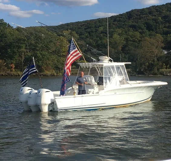  Yacht Photos Pics 2017 Buddy Davis 34 Center Console boat with flags on a scenic lake.
