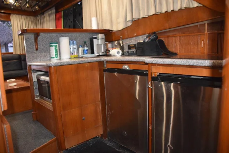 Main One Yacht Photos Pics 2000 Custom Carolina Wetsig Yachts Cape Fear kitchen with stainless steel appliances and wooden cabinetry.