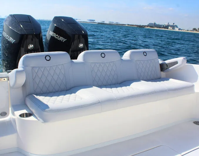  Yacht Photos Pics Luxury seating on 2025 Fountain 34 CC boat with dual Mercury engines, ocean backdrop.