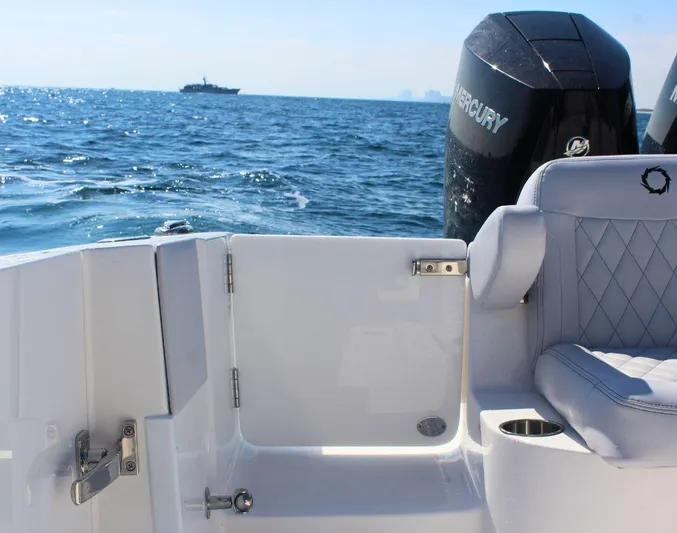  Yacht Photos Pics 2025 Fountain 34 CC boat interior with Mercury engine, ocean view in background.
