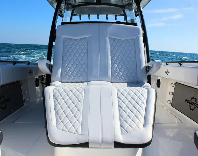  Yacht Photos Pics 2025 Fountain 34 CC boat with luxurious white quilted seating, ocean backdrop.