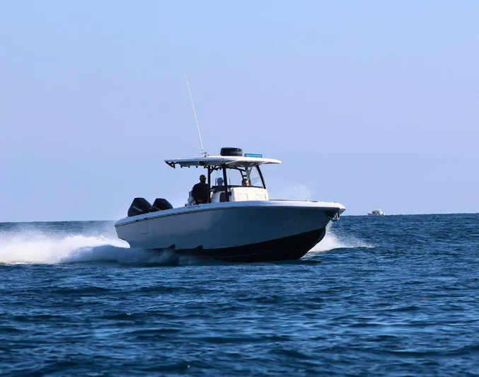 Yacht Photos Pics 2025 Fountain 34 CC boat cruising on open water under clear blue sky.