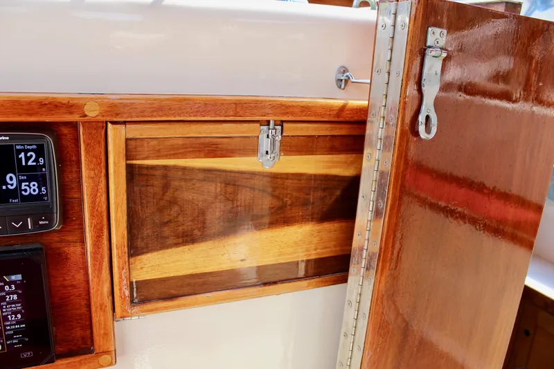 Phoenix Rising Yacht Photos Pics Wooden interior of 1981 Skookum 53 boat with navigation instruments and storage compartment.