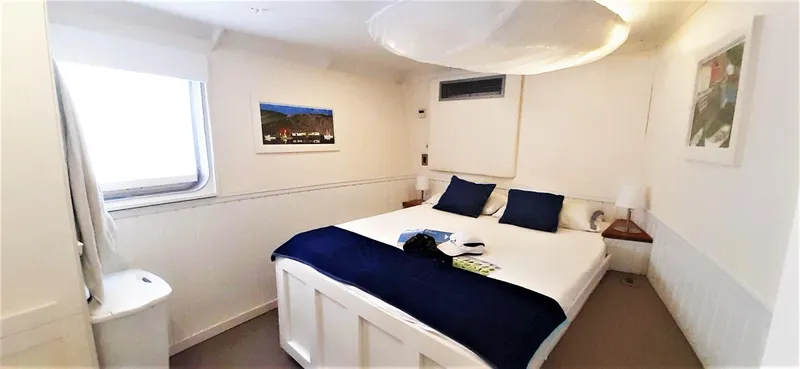  Yacht Photos Pics Cozy bedroom on 2004 Custom Bon Pelley catamaran with white decor and blue accents.