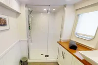 Modern bathroom on 2004 Custom Bon Pelley catamaran with shower, sink, and window.