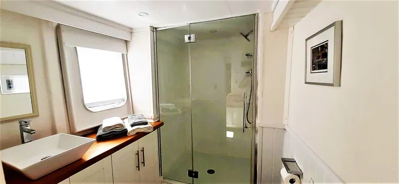  Yacht Photos Pics Luxurious bathroom on 2004 Custom Bon Pelley catamaran with glass shower and modern fixtures.