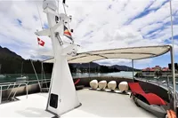Luxurious 2004 Custom Bon Pelley catamaran with shaded deck, scenic marina view.