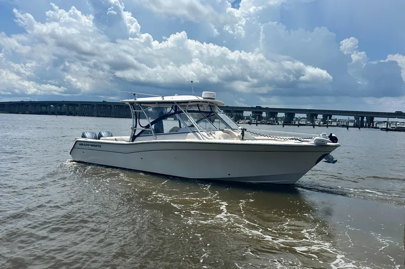  Yacht Photos Pics 2012 Grady-White Freedom 307 boat on water, under cloudy sky near a bridge.