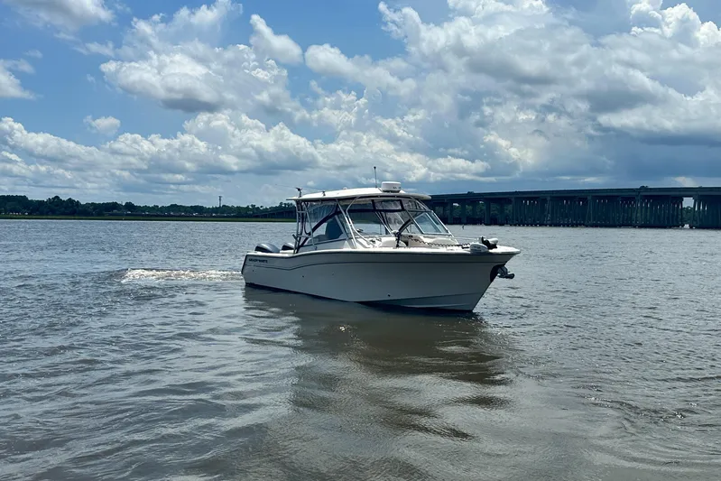  Yacht Photos Pics 2012 Grady-White Freedom 307 boat cruising on a calm river under cloudy skies.