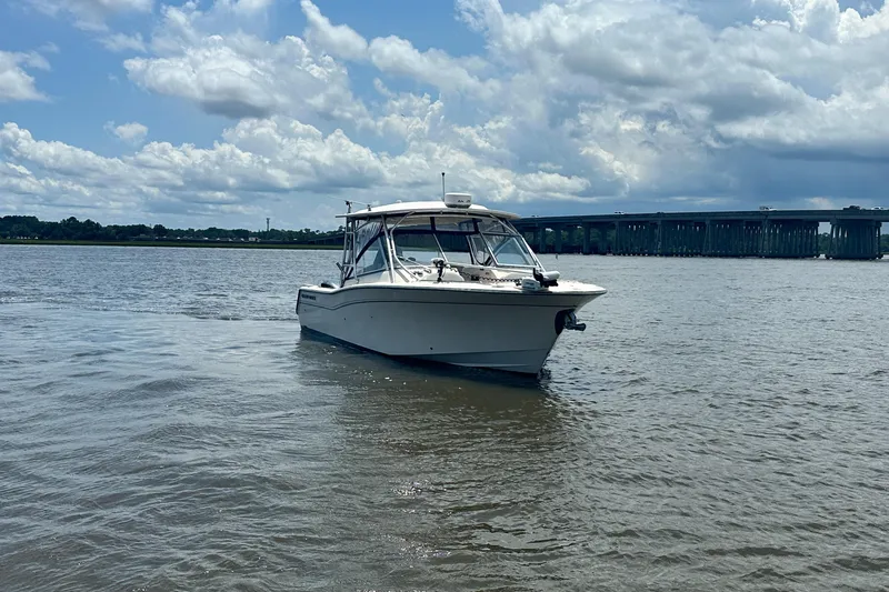  Yacht Photos Pics 2012 Grady-White Freedom 307 boat on water near a bridge under cloudy sky.