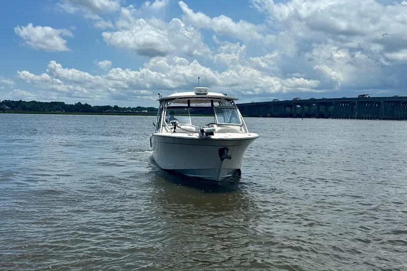  Yacht Photos Pics 2012 Grady-White Freedom 307 boat on a calm river under a cloudy sky.