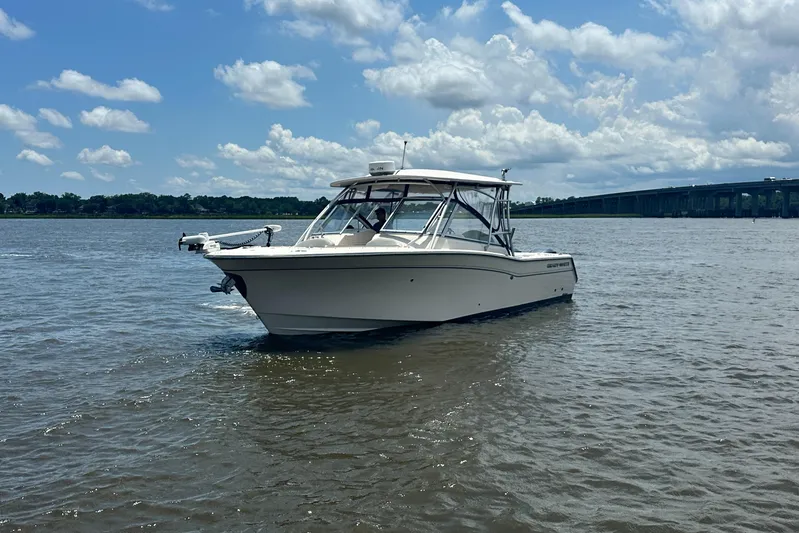  Yacht Photos Pics 2012 Grady-White Freedom 307 boat on calm water under a partly cloudy sky.