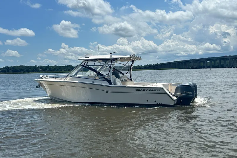  Yacht Photos Pics 2012 Grady-White Freedom 307 boat cruising on a sunny day with bridge in background.