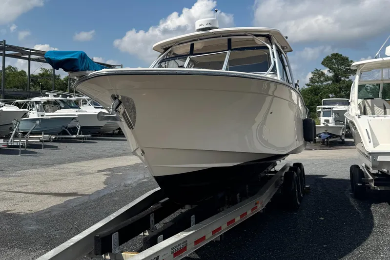  Yacht Photos Pics 2012 Grady-White Freedom 307 boat on trailer, parked in marina under cloudy sky.