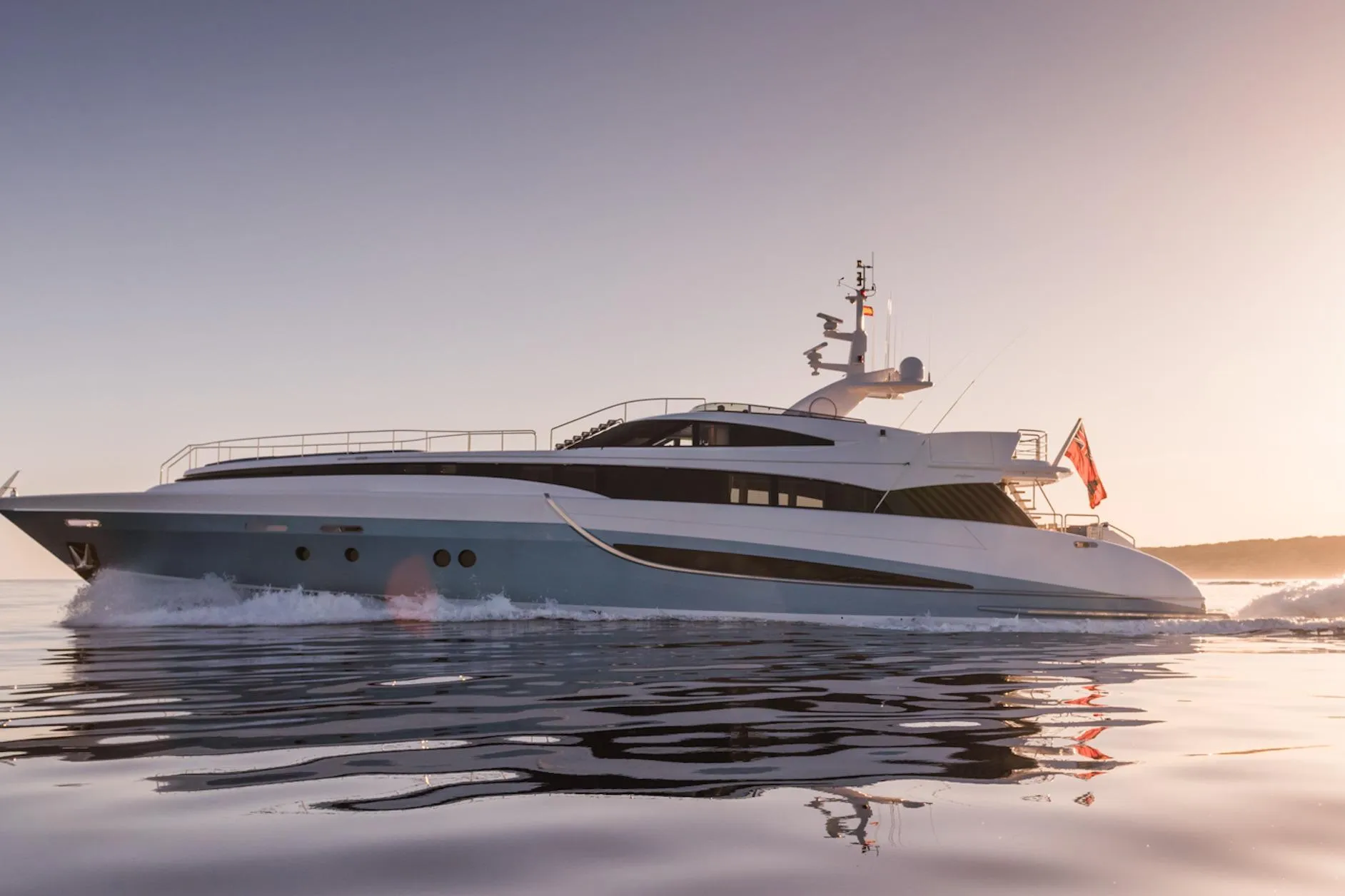 Luxury yacht Evolution 110, 2005 model, cruising at sunset on calm waters.