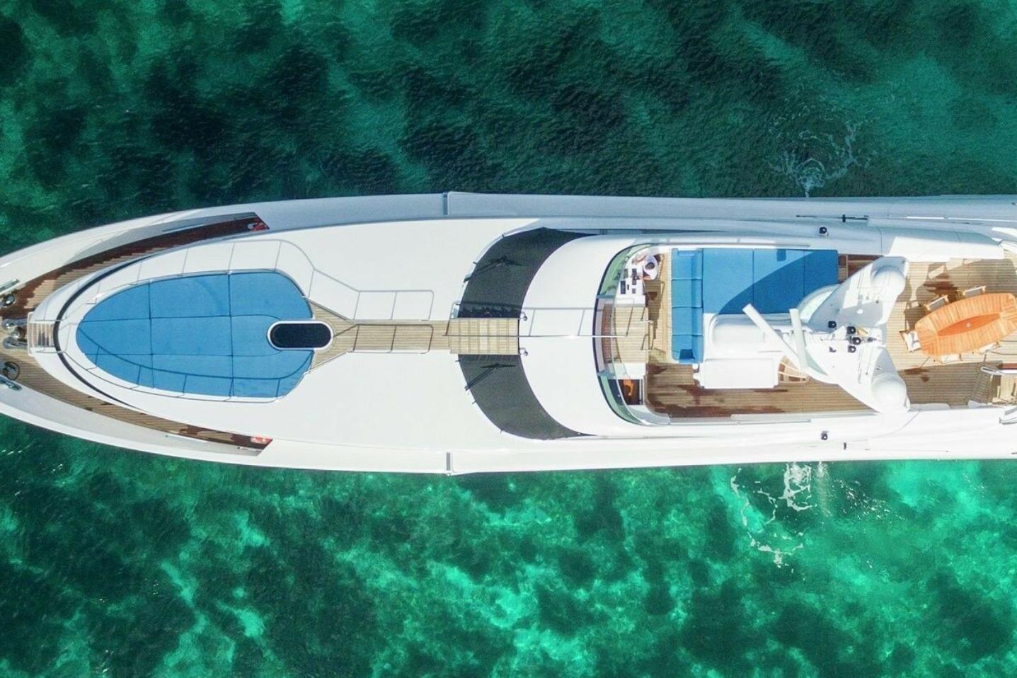 Aerial view of 2005 Evolution 110 yacht on clear turquoise water.