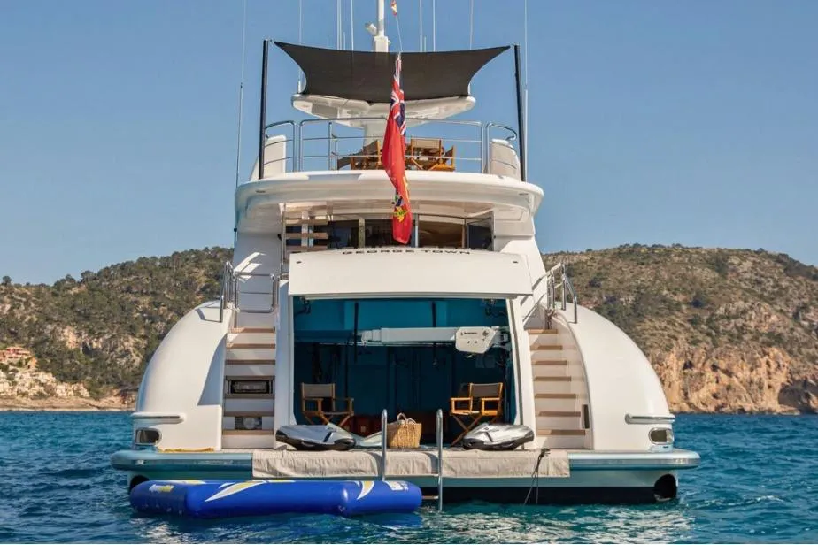 Luxury yacht Evolution 110, 2005 model, anchored in scenic coastal waters.