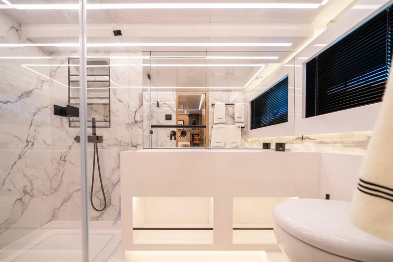  Yacht Photos Pics Luxurious modern bathroom with marble walls, sleek fixtures, and ambient lighting in a Pearl 62 yacht.