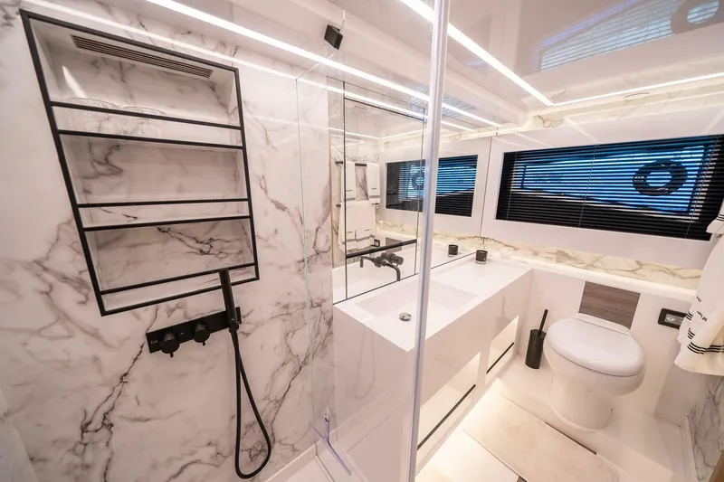  Yacht Photos Pics Luxurious bathroom in 2023 Pearl 62 yacht with marble walls and modern fixtures.