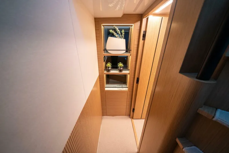  Yacht Photos Pics Modern interior of 2023 Pearl 62 yacht with elegant wooden paneling and decorative plants.