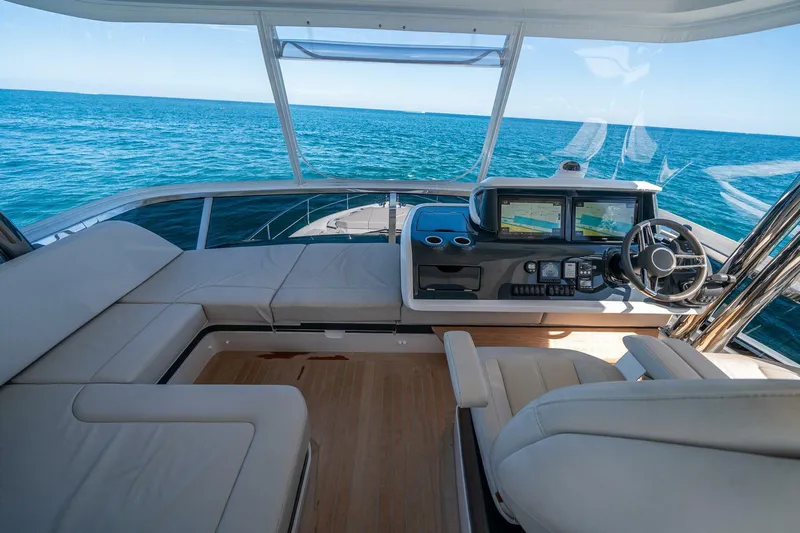  Yacht Photos Pics Luxurious 2023 Pearl 62 yacht interior with ocean view, featuring modern helm and seating.