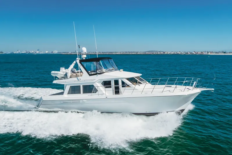  Yacht Photos Pics 2003 Navigator 53 yacht cruising on blue ocean with city skyline in background.