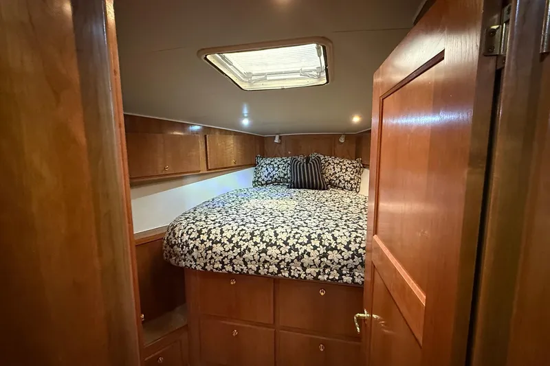  Yacht Photos Pics Cozy bedroom in 2003 Navigator 53 yacht with floral bedding and wooden cabinetry.