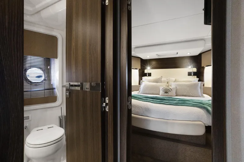  Yacht Photos Pics Luxurious interior of 2019 Azimut 50 Fly yacht featuring cozy bedroom and modern bathroom.