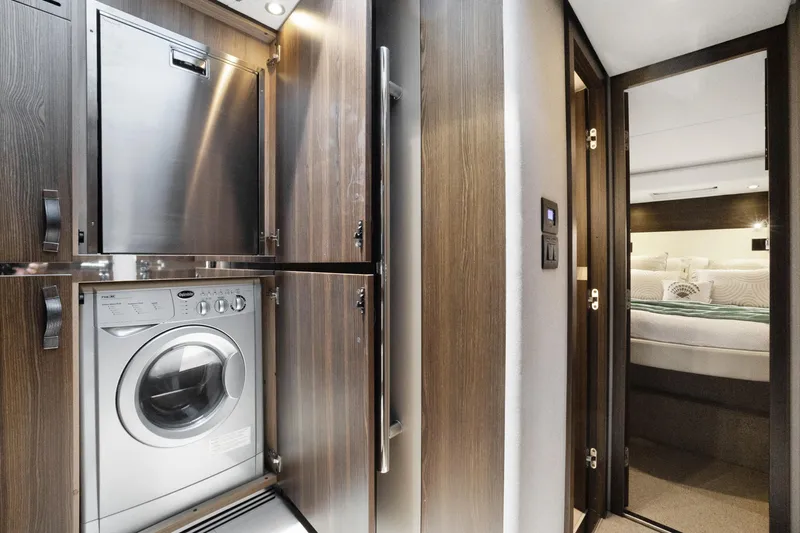  Yacht Photos Pics Laundry area and bedroom in 2019 Azimut 50 Fly yacht, featuring modern wood cabinetry.