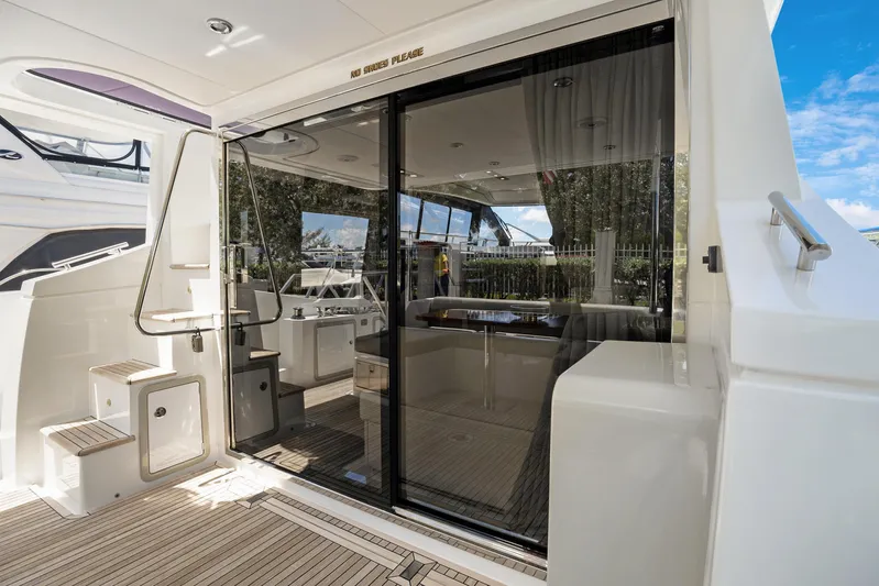  Yacht Photos Pics 2019 Azimut 50 Fly yacht interior with glass doors and wooden deck.