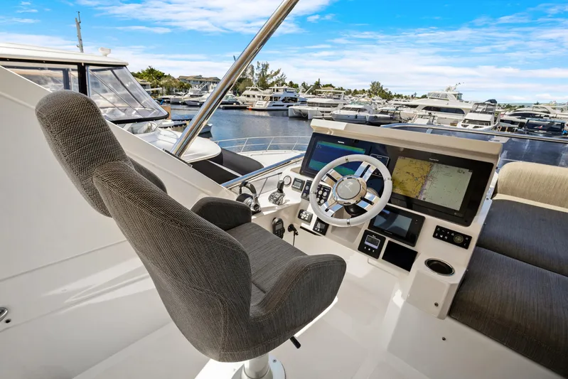  Yacht Photos Pics 2019 Azimut 50 Flybridge yacht helm with navigation screens and marina view.