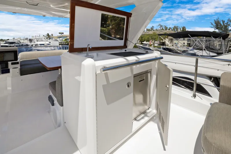  Yacht Photos Pics 2019 Azimut 50 Fly yacht interior with open cabinet and seating area.