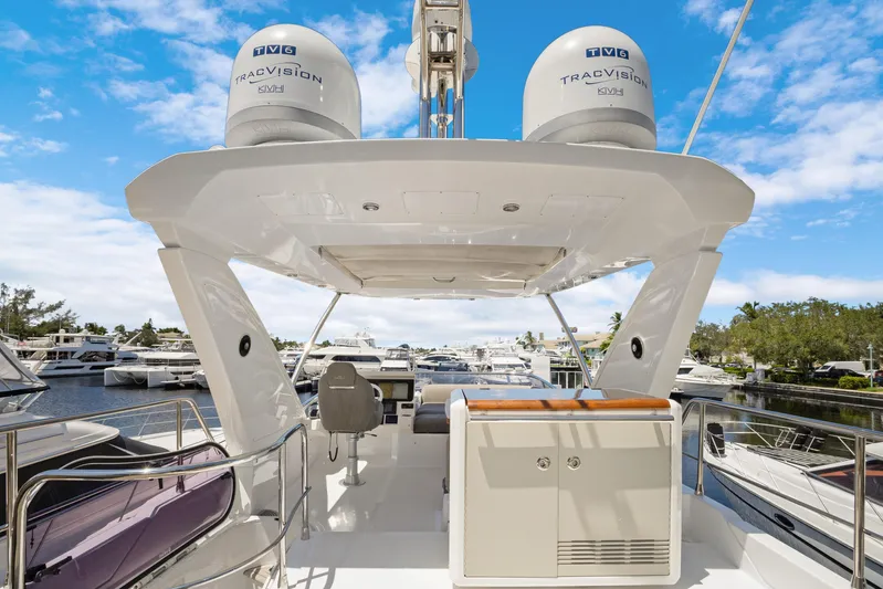  Yacht Photos Pics 2019 Azimut 50 Fly yacht with TracVision domes, docked in a marina under blue skies.