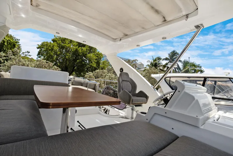  Yacht Photos Pics Luxurious 2019 Azimut 50 Fly yacht interior with seating and table, surrounded by lush greenery.