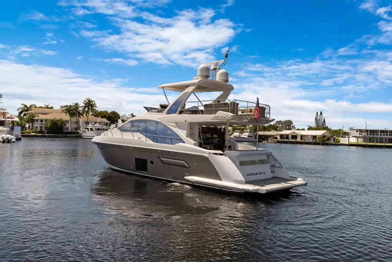  Yacht Photos Pics 2019 Azimut 50 Fly yacht cruising on a serene waterway under a clear blue sky.