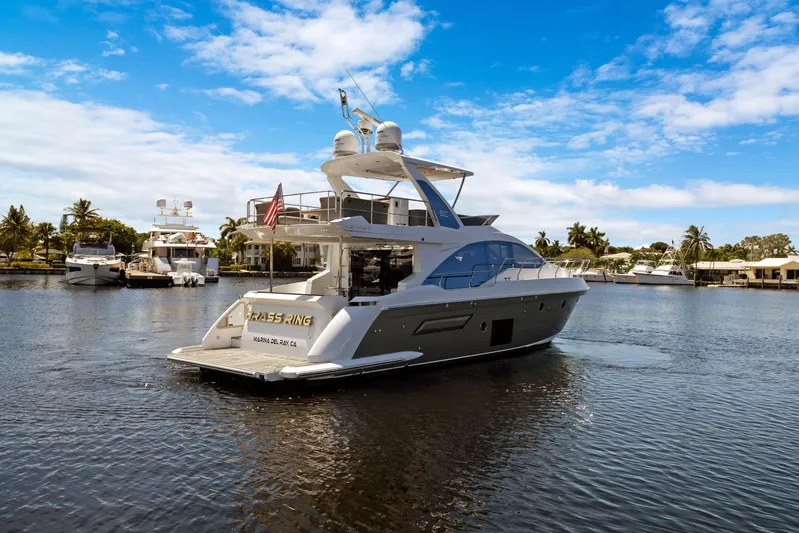  Yacht Photos Pics 2019 Azimut 50 Fly yacht on calm water, clear sky, and palm trees in the background.
