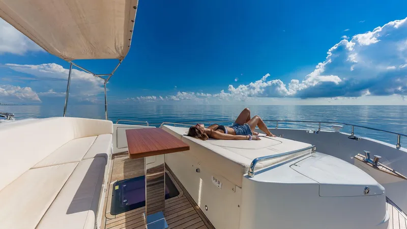 Golden 3 Yacht Photos Pics Woman relaxing on 2015 Dominator 800 yacht under clear blue sky.