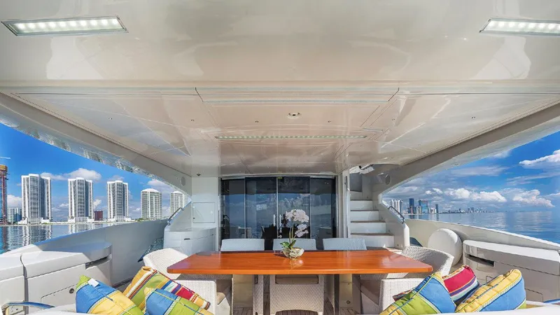 Golden 3 Yacht Photos Pics Luxurious 2015 Dominator 800 yacht deck with dining area and city skyline view.