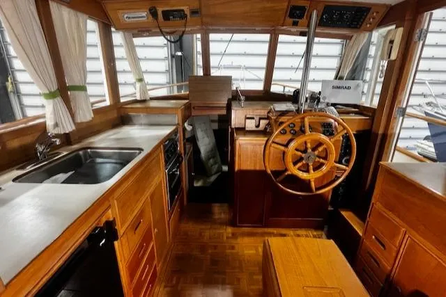 North Star Yacht Photos Pics 1984 Grand Banks Trawler interior with wooden helm, kitchen, and navigation equipment.