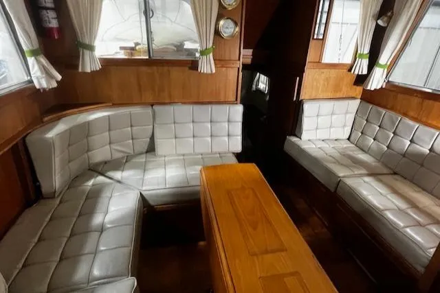 North Star Yacht Photos Pics 1984 Grand Banks Trawler interior with cushioned seating and wooden table.