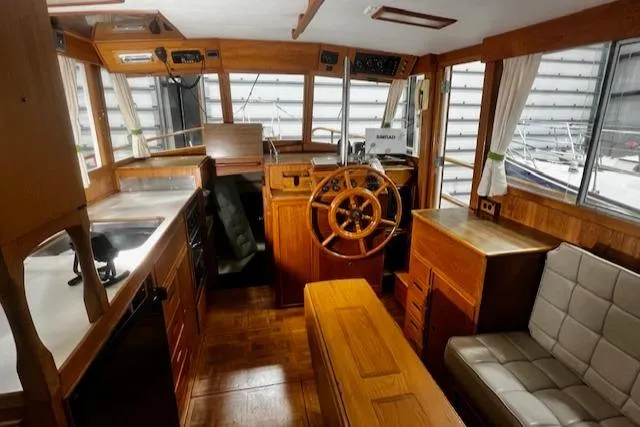 North Star Yacht Photos Pics 1984 Grand Banks Trawler interior with wooden helm, seating, and kitchen area.