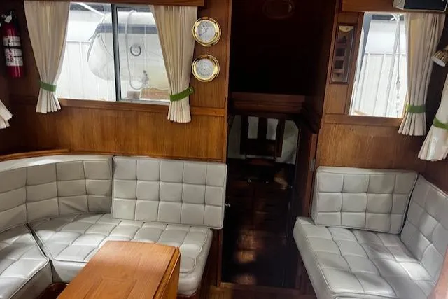 North Star Yacht Photos Pics 1984 Grand Banks Trawler interior with white cushioned seating and wooden accents.