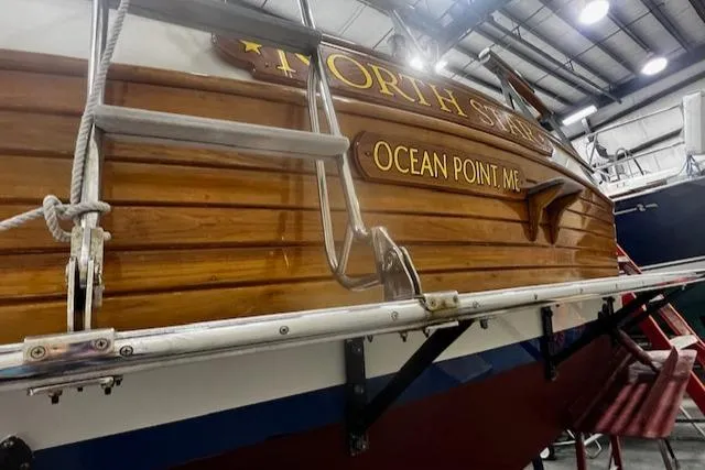 North Star Yacht Photos Pics 1984 Grand Banks Trawler in a boatyard, featuring wooden hull and ladder.
