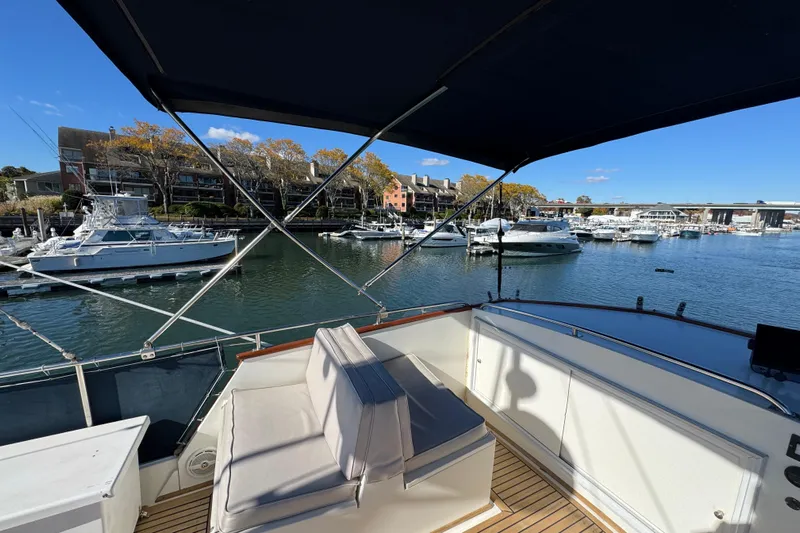  Yacht Photos Pics 1988 Grand Banks 42 Classic yacht docked in a scenic marina with waterfront buildings.