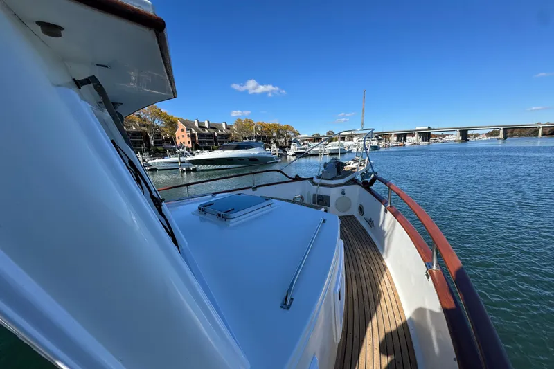  Yacht Photos Pics 1988 Grand Banks 42 Classic yacht docked in a scenic marina under clear blue skies.