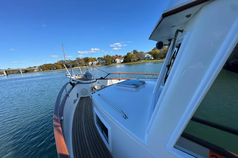  Yacht Photos Pics 1988 Grand Banks 42 Classic yacht on serene water with clear blue sky.