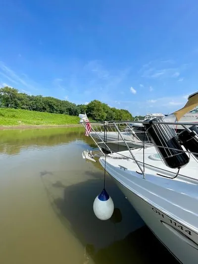 "kimberly Cay" Yacht Photos Pics 2003 Carver 360 Sport Sedan docked on a sunny day by a riverbank.