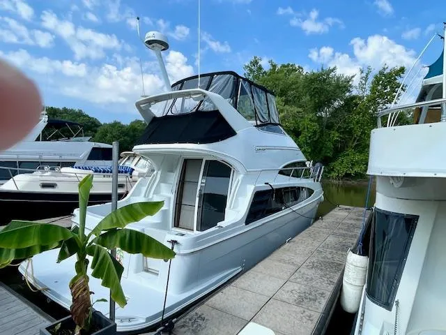 "kimberly Cay" Yacht Photos Pics 2003 Carver 360 Sport Sedan docked, surrounded by lush greenery and other boats.